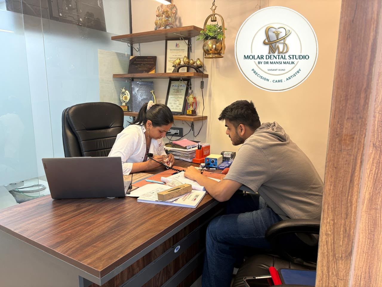 Dr. Mansi Dahiya Malik going through a treatment plan with a patient at the consultation desk